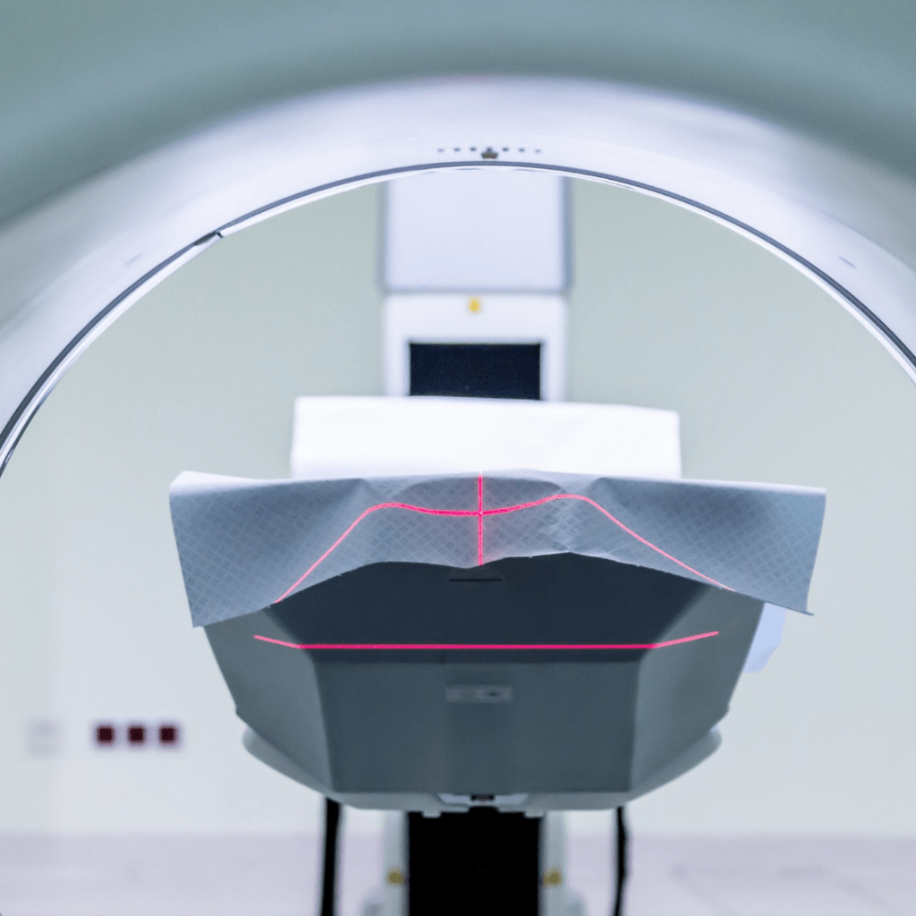MRI machine. A red laser guide is placed on the patient to set up the scanning area.